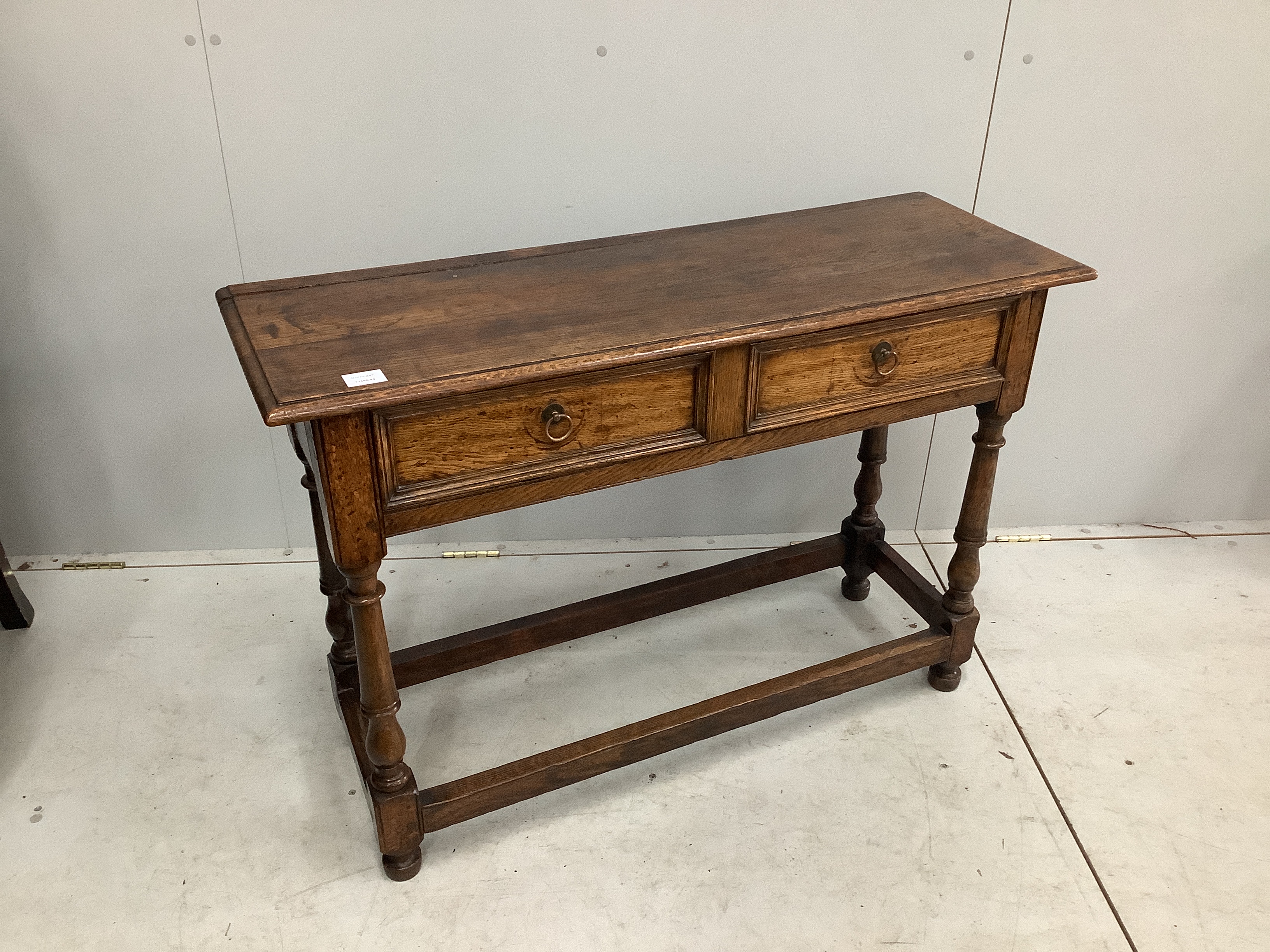 An early 18th century style oak two drawer side table, width 107cm, depth 36cm, height 72cm